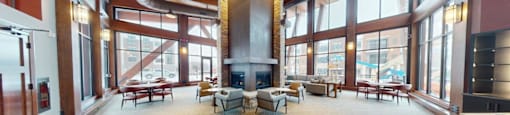 A large open room with a fireplace and lots of windows.