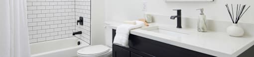 a black and white bathroom with a shower and a sink
