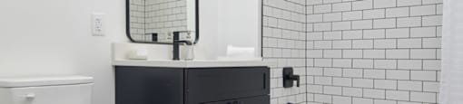 a black and white bathroom with a toilet and a shower