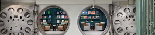 A room with a table and chairs in front of a wall with circular windows. at The Commonwealth, Philadelphia, Pennsylvania