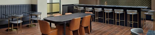 A modern dining room with a dark wood table and chairs.