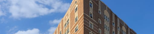 A large brick building with many windows is in the foreground.