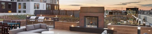 a rendering of a rooftop patio with couches and a fireplace