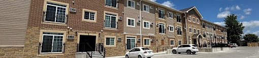 a large brick apartment building with cars parked outside