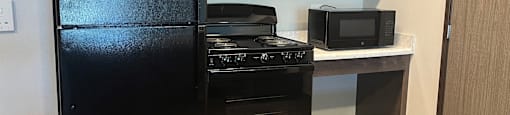 a kitchen with black appliances and a counter with a refrigerator