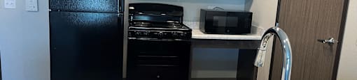 a kitchen with a sink and a black refrigerator