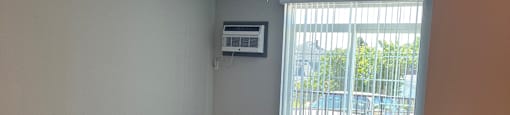 an empty living room with a ceiling fan and a window