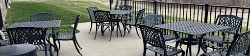 A black metal table and chairs are set up on a patio.