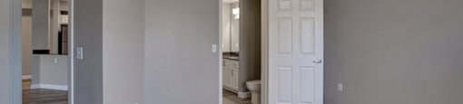 a room with a ceiling fan and a door to a bathroom