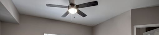 an empty bedroom with a ceiling fan