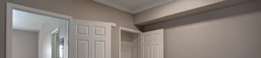 a bedroom with two doors and a door to a bathroom