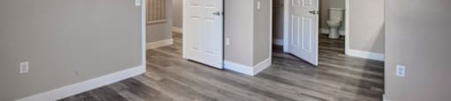 a bedroom with a ceiling fan and three doors