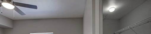 an empty room with a window and a ceiling fan