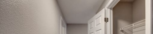 a hallway with an open door and a closet