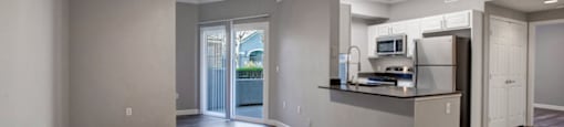 a kitchen and living room with a ceiling fan