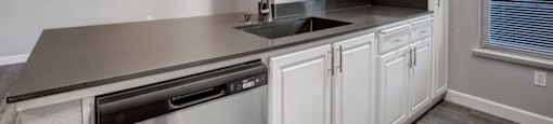 a kitchen with a sink and a ceiling fan
