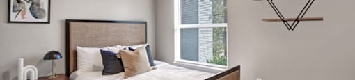 a bedroom with a large window and a ceiling fan