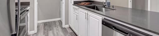 a kitchen with white cabinets and stainless steel appliances