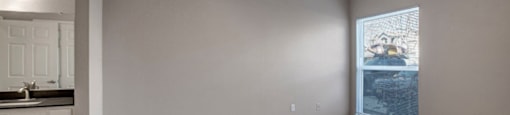 an empty room with a ceiling fan and a window