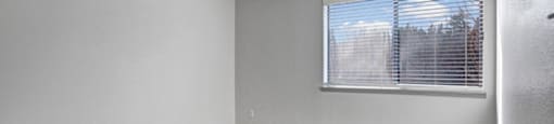 an empty bedroom with a large window
