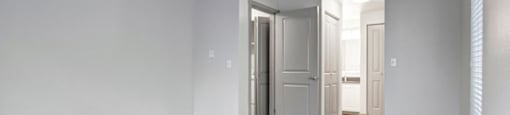 a bedroom with white walls and gray carpet