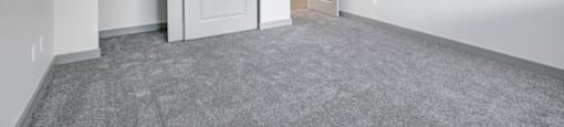 an empty bedroom with a closet and a door open