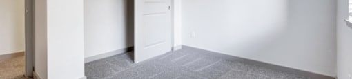 a bedroom with white walls and a closet with a white door