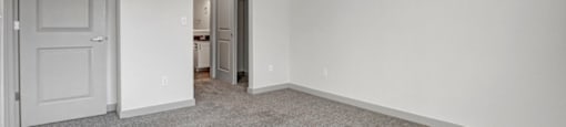 a bedroom with white walls and carpet