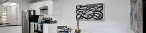 a kitchen and a dining room with a table and chairs