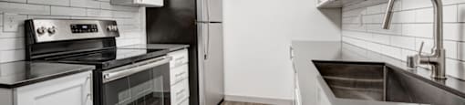 a kitchen with white cabinets and black appliances