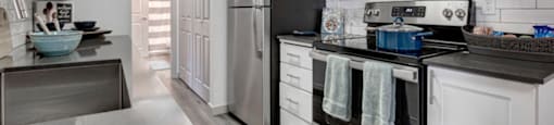 a kitchen with a stove top oven next to a refrigerator