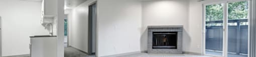 a living room with a fireplace and a kitchen