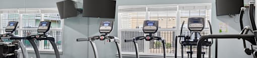 A gym with treadmills and elliptical machines.