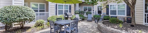 a patio with a table and chairs under a yellow umbrella