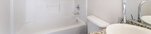 a white bathroom with a tub and a sink