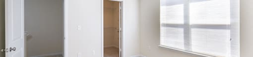 a bedroom with a large window and a door to a hallway