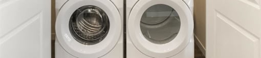 a washer and dryer in a laundry room with white doors