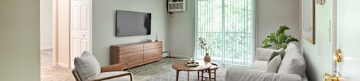 A living room with a grey couch, a wooden chair, and a television.