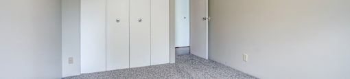 A room with a carpeted floor and a white ceiling with a light fixture.