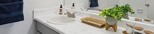 a white bathroom with a sink and a mirror