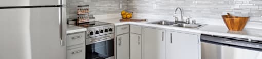 a white kitchen with stainless steel appliances and white cabinets
