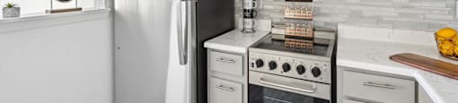 a kitchen with white cabinets and appliances and a refrigerator