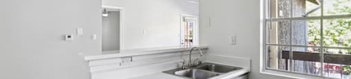 an empty kitchen with a sink and a window