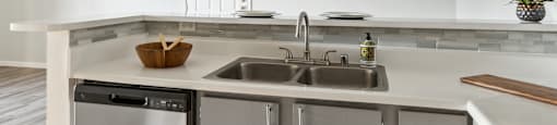an empty kitchen with stainless steel appliances and a sink