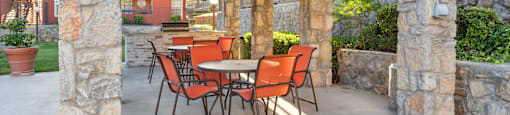 a patio with a table and chairs under a pergola