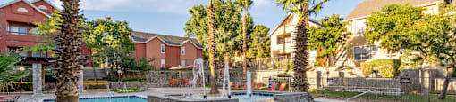 a swimming pool with a fountain and palm trees