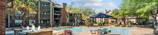 A pool area with a blue vase in the foreground.