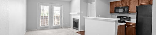 A spacious living room with a kitchenette and a fireplace.