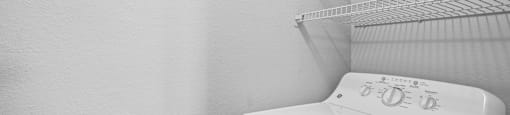 A white washing machine sits in a laundry room.
