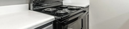 A black stove top oven with a microwave above it.